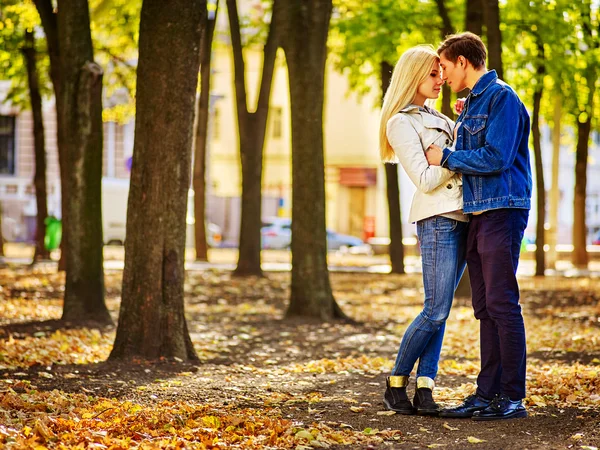 Loving couple kissing in sun autumn park.