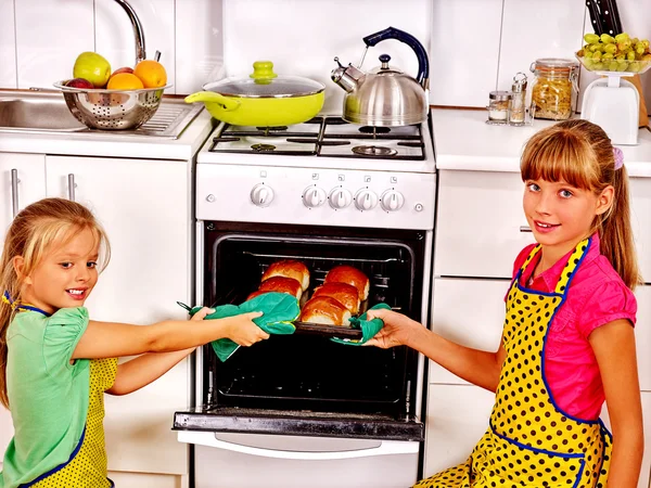 Children show how easy to bake buns in oven.