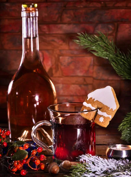 Winter hot drink with cookie and bottle of wine.