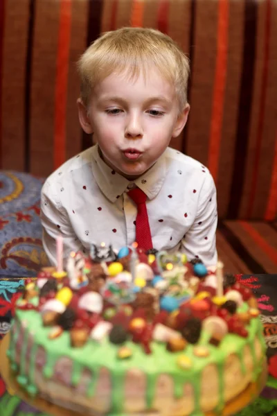 Child blowing out candles on birthday cake