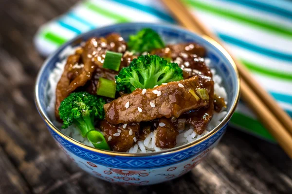 Beef in sauce with broccoli and rice on bowl