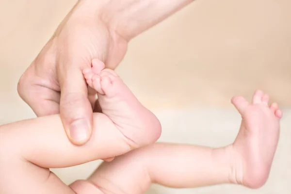 Baby feet in dad\'s hand with a blurred background