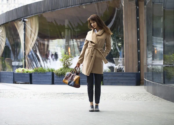 Portrait of a young beautiful woman in beige coat