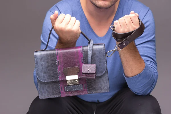 Strong male hands holding handbags
