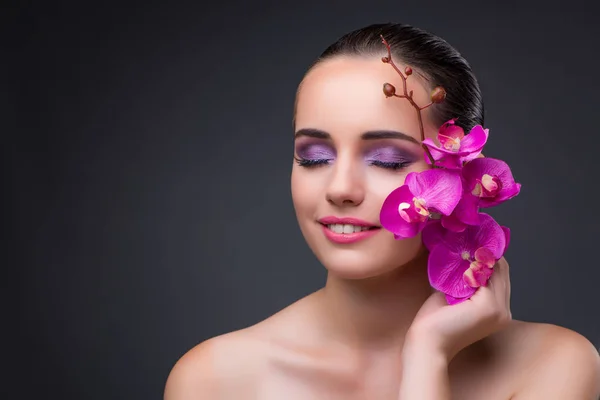 Young beautiful woman with orchid flower