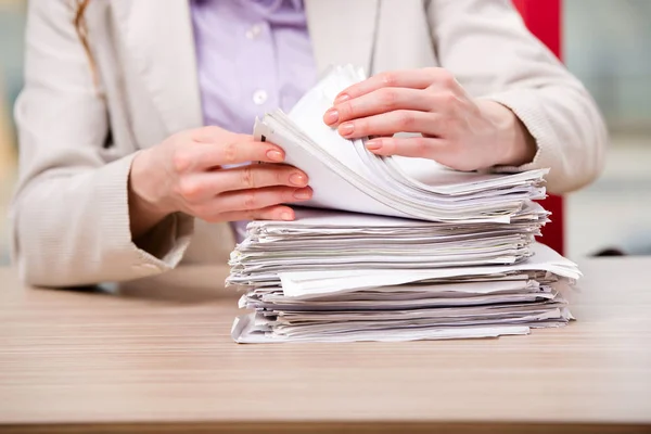 Businesswoman working with stack of papers