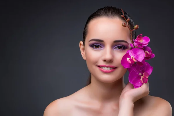 Young beautiful woman with orchid flower