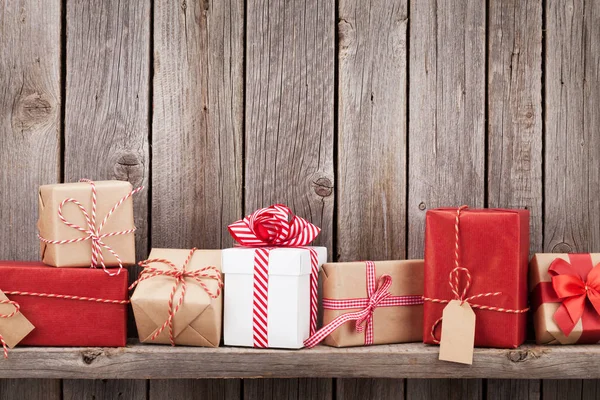 Christmas gift boxes in front of wooden wall