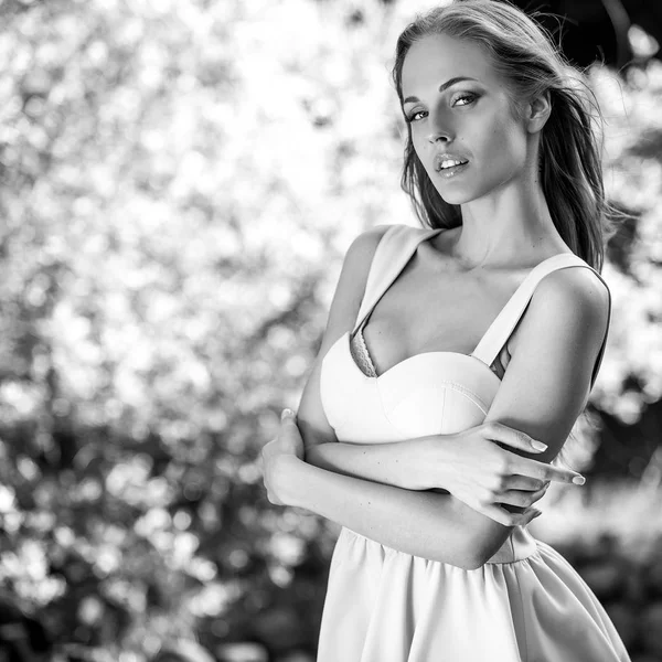Black-white outdoor portrait of beautiful young sexual blonde woman against nature background.