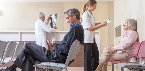 Patients and doctors speaking inside hospital waiting room