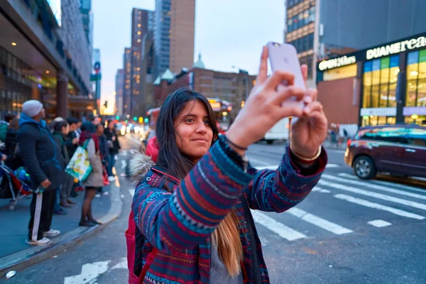 Woman taking photos in New York at evening.