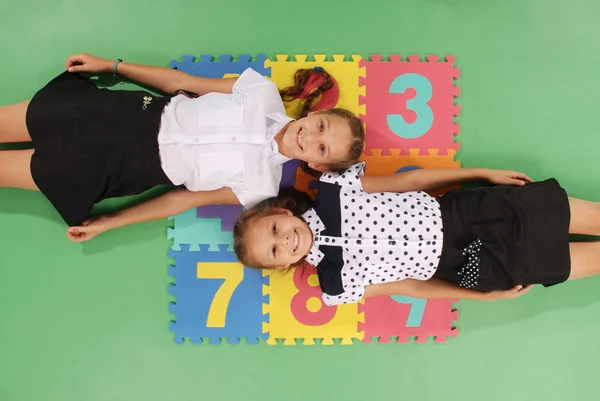 Two girls on rug with numbers