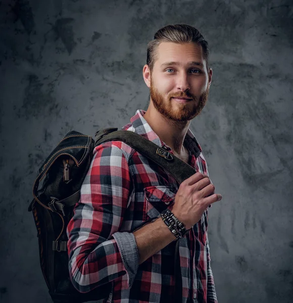 Redhead urban traveller holds backpack
