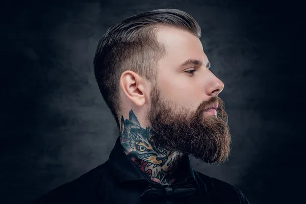 Bearded hipster male with tattoo on his neck.