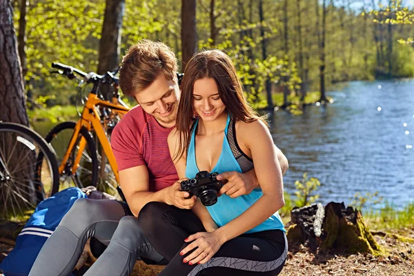 Smiling male showing pictures to his girlfriend