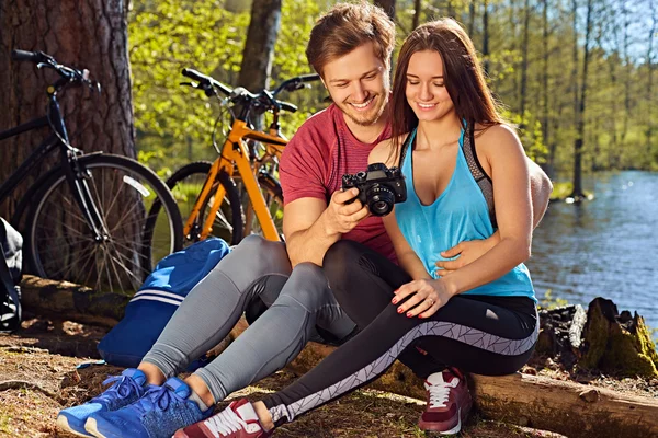 Smiling male showing pictures to his girlfriend