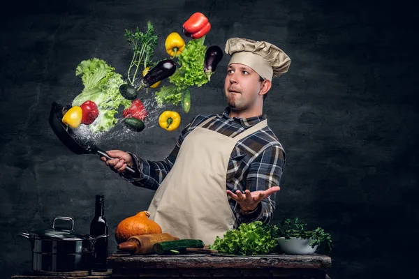 Chef with vegetables flying in the  air.