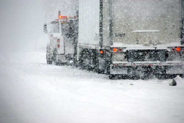 Trucks on winter highway during snowstorm