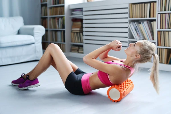 Woman exercises with foam roller
