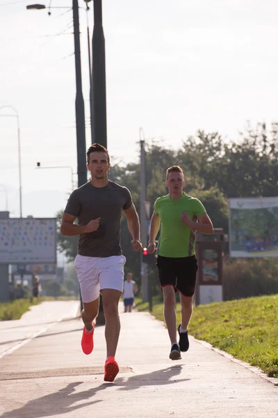 Two young men jogging through the city