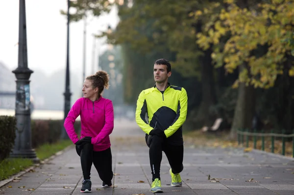 Couple warming up before jogging