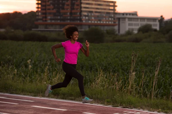 A young African American woman jogging outdoors