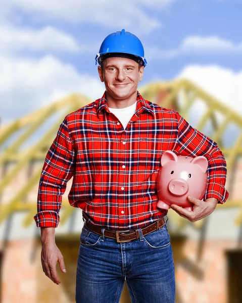 Worker with piggy bank. Construction and house renovation concep