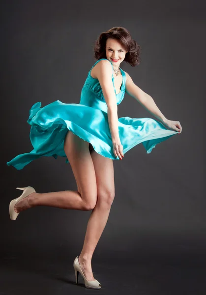 Young elegant woman in a green dress in a dynamic pose