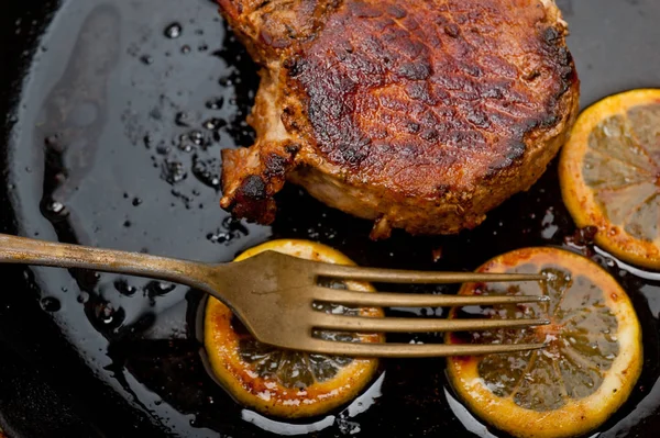 Pork chop seared on iron skillet