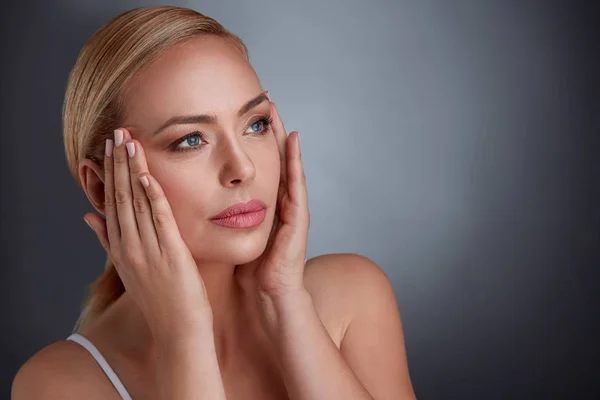 Woman tightening skin on face to make you look younger