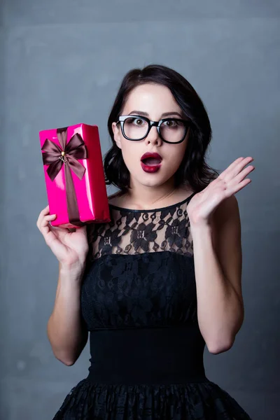 Woman in black dress with gift