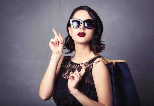 Woman in black dress with shopping bag