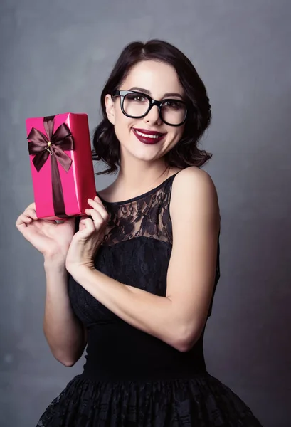 Woman in black dress with gift