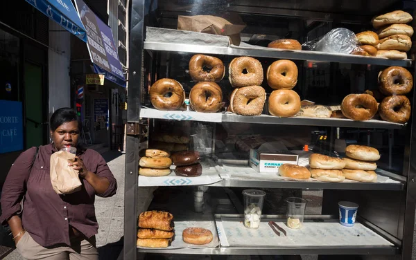 Manhattan street scene. Fat black woman buys buns on the streets