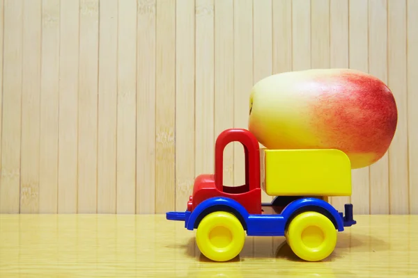 Toy plastic car with red apple