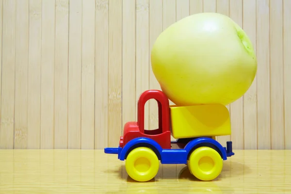 Toy plastic car with green apple