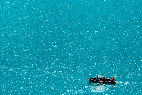 Unrecognizable people rowing in boat on lake