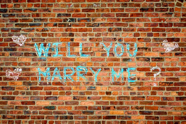 Brick wall with the text :  Wll you marry me?