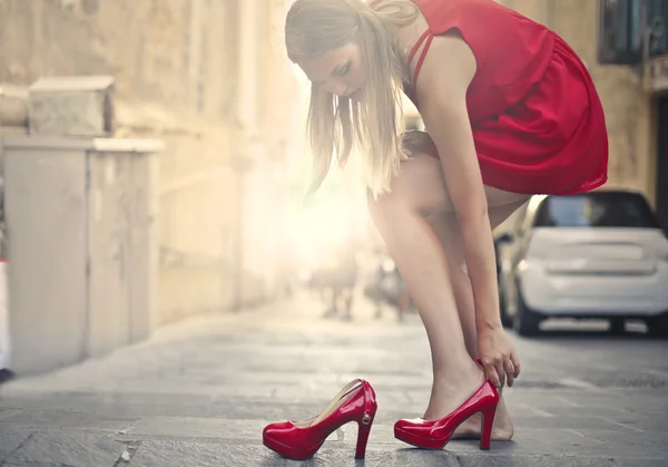 Woman is taking off high-heeled shoes