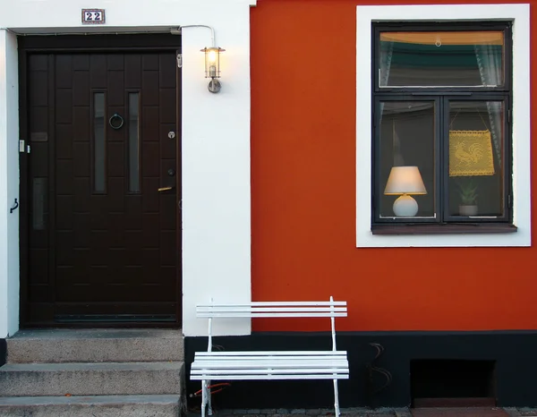 Beautiful building with red wall and white bench