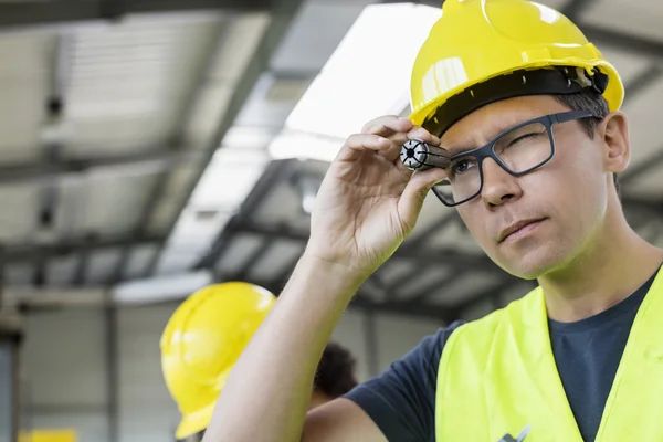Manual worker examining metal in industry