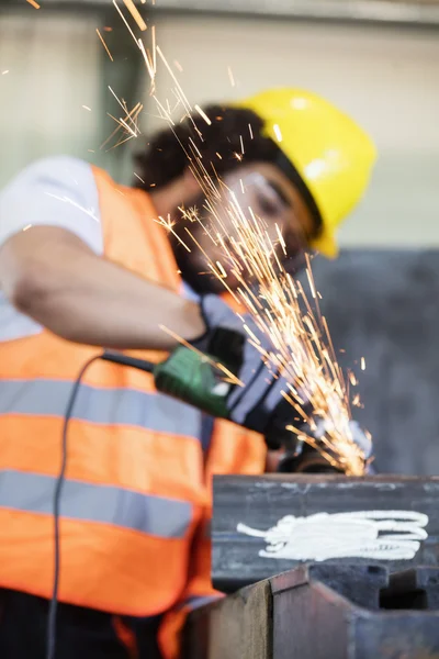 Sparks coming out from grinder with worker