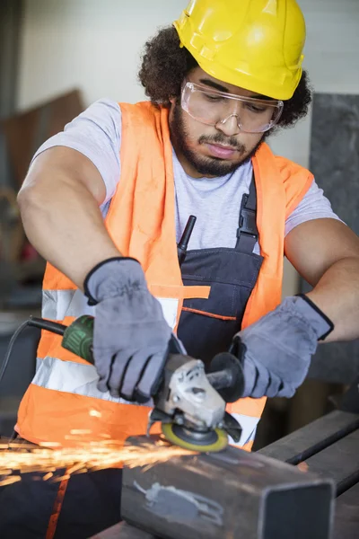 Manual worker grinding metal in industry