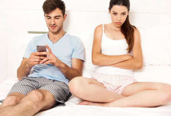 Man looking cellphone while woman angry