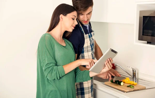 Couple looking recipe in tablet