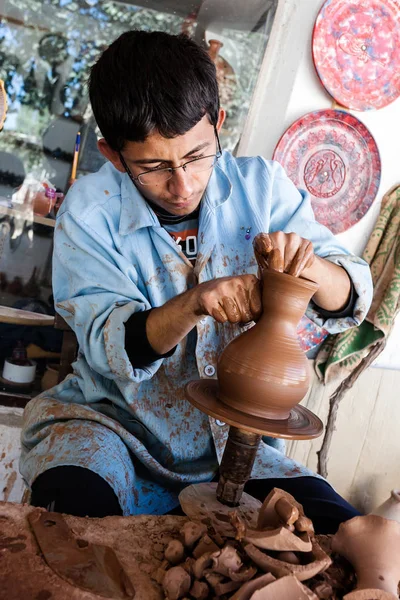 An unknown artist works on a traditional ceramic vase in Cappado