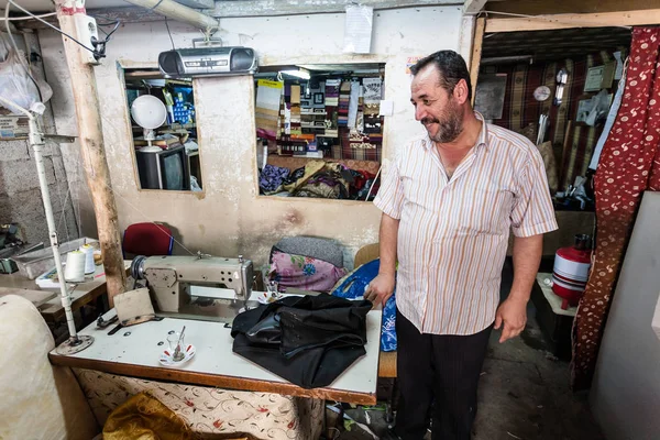 An unknown man in his workshop where he repairs furniture