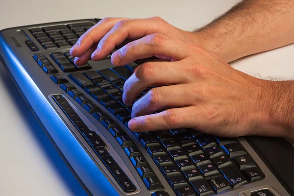 man typing on a laptop computer