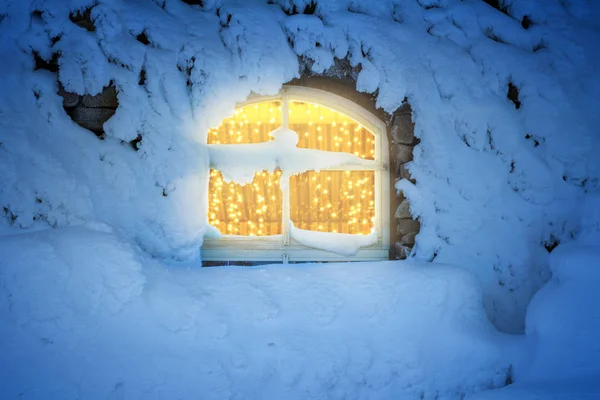 Light decoration in the window in a cold, snowy winter night