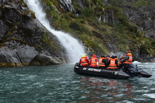 Tourists from the cruise ship near the waterfalls of the glacier Nena.
